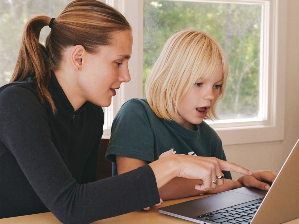Parent and kid looking at a laptop together